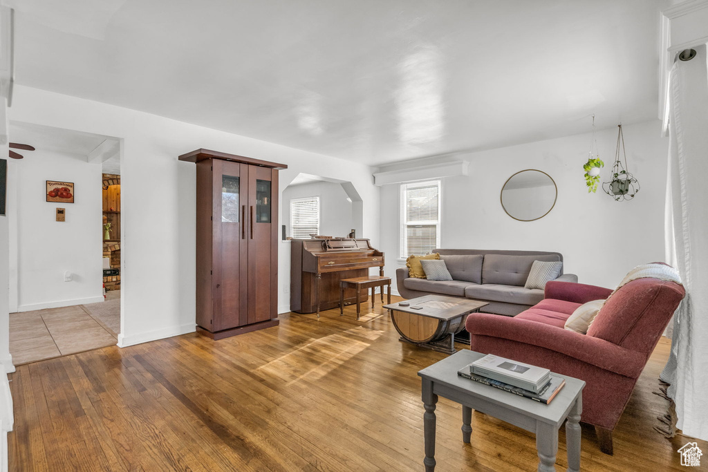 Living area with wood finished floors, baseboards, and arched walkways