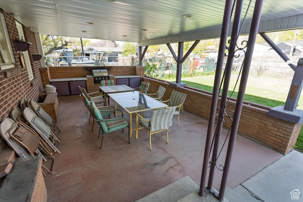 View of patio / terrace featuring area for grilling, outdoor dining space, an outdoor kitchen, and fence