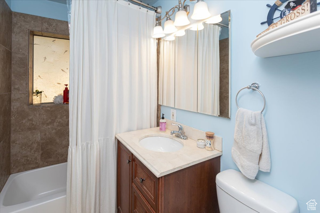 Full bathroom featuring shower / tub combo, a notable chandelier, toilet, and vanity