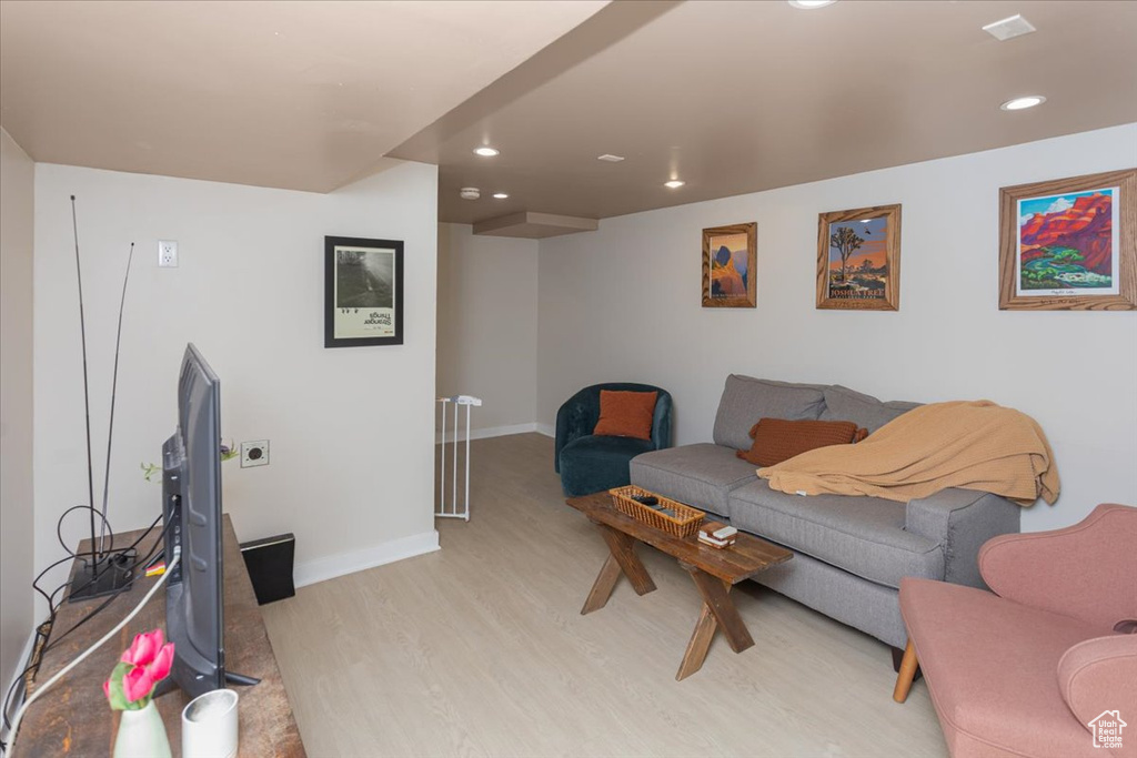 Living room with light wood finished floors, recessed lighting, and baseboards