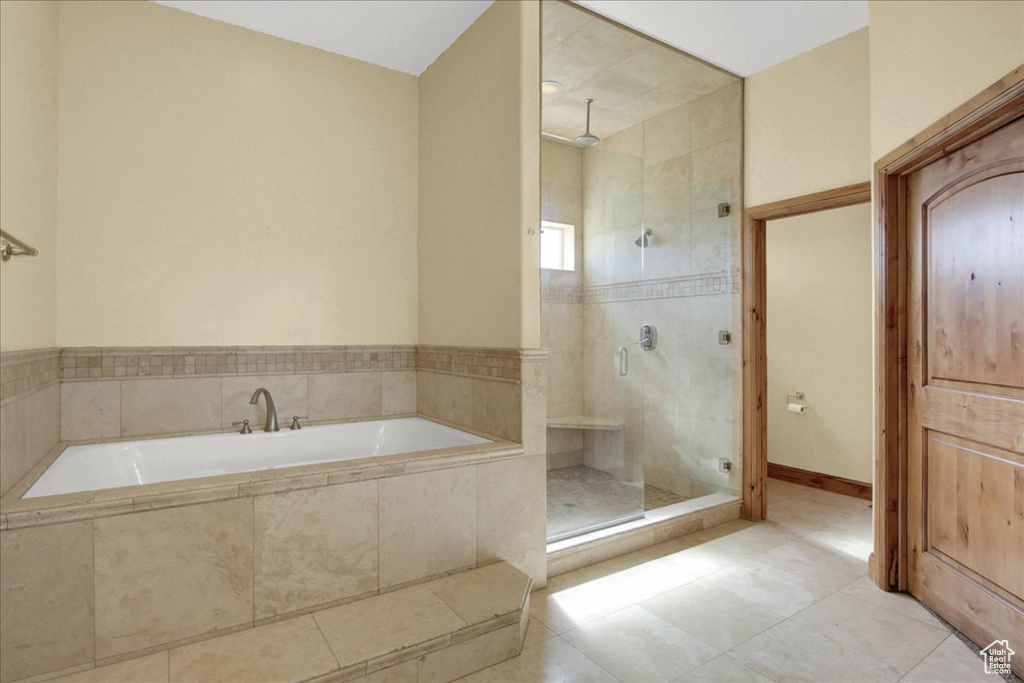Bathroom with a shower stall, a garden tub, and tile patterned flooring