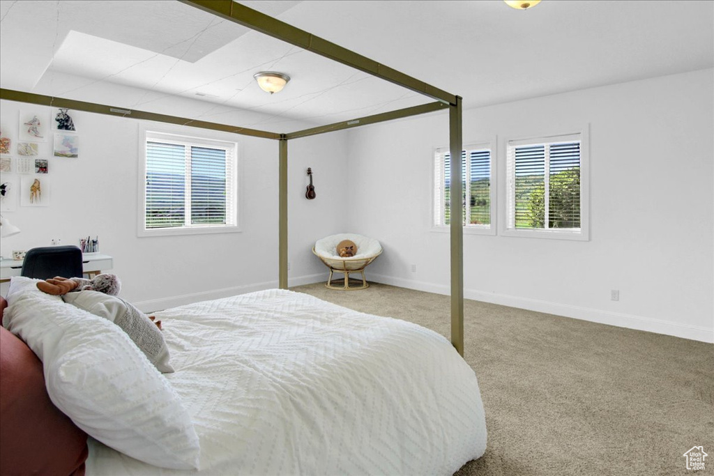 Bedroom featuring carpet and baseboards