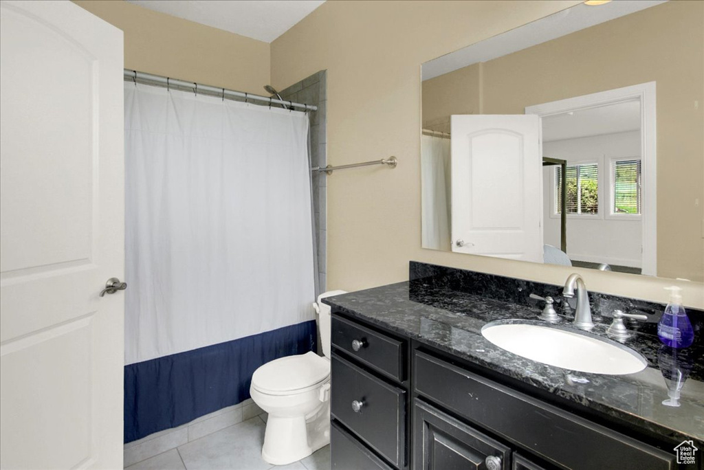 Full bath with tile patterned floors, toilet, curtained shower, and vanity
