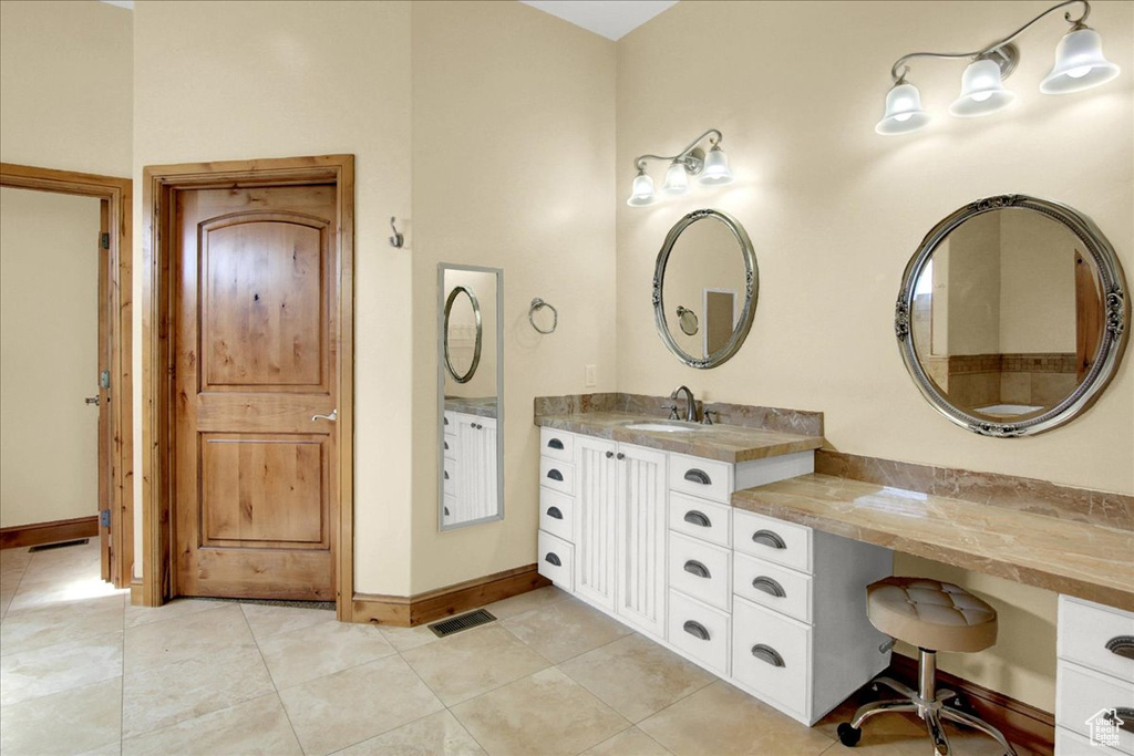 Bathroom featuring tile patterned floors, visible vents, vanity, and baseboards