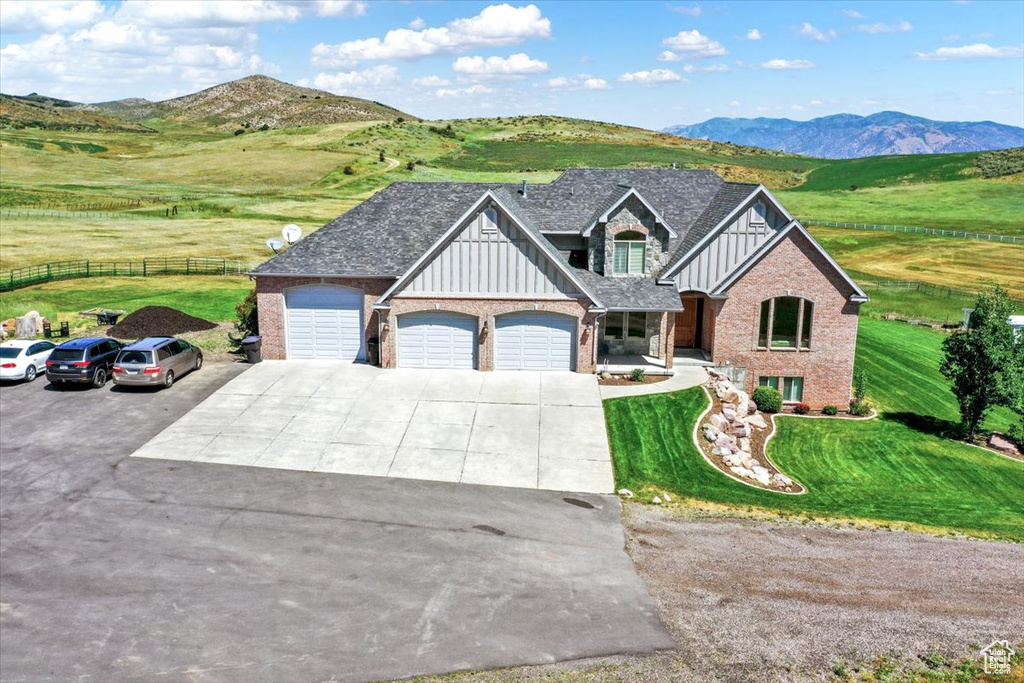 Craftsman house featuring a front yard, a garage, driveway, board and batten siding, and fence
