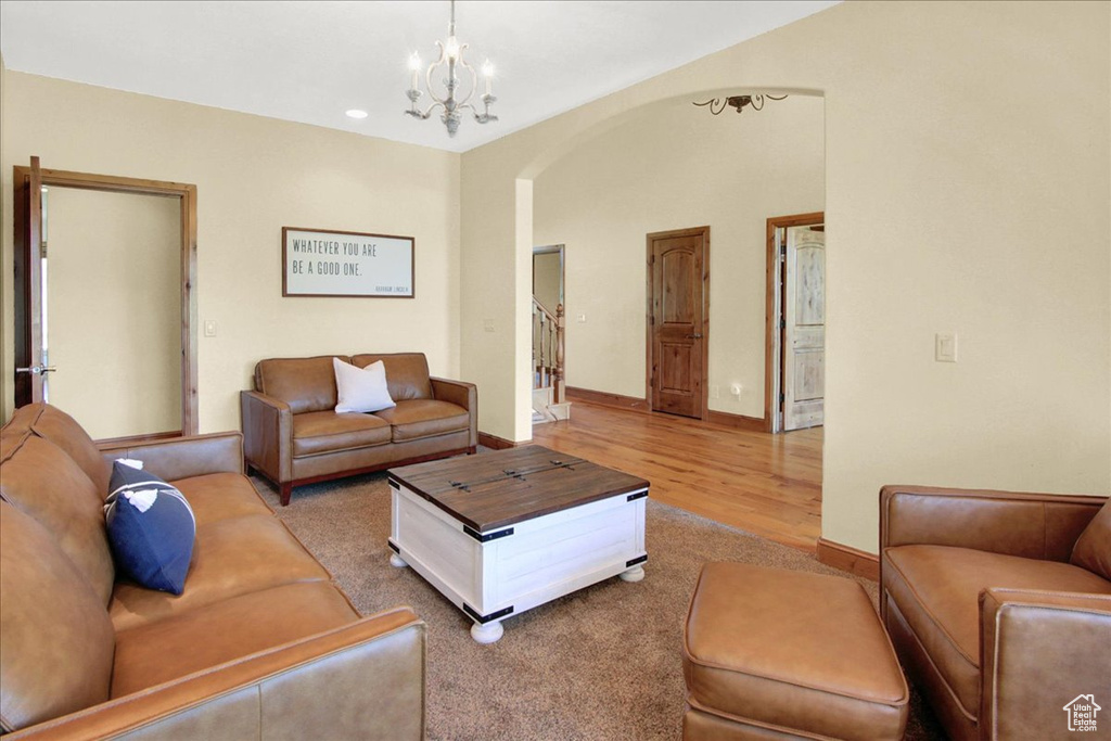 Living area featuring recessed lighting, arched walkways, wood finished floors, a chandelier, and baseboards