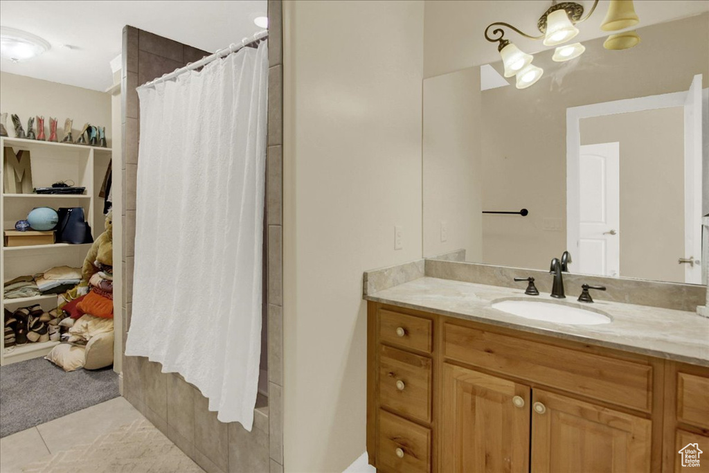Full bathroom featuring a chandelier, vanity, tile patterned flooring, and curtained shower
