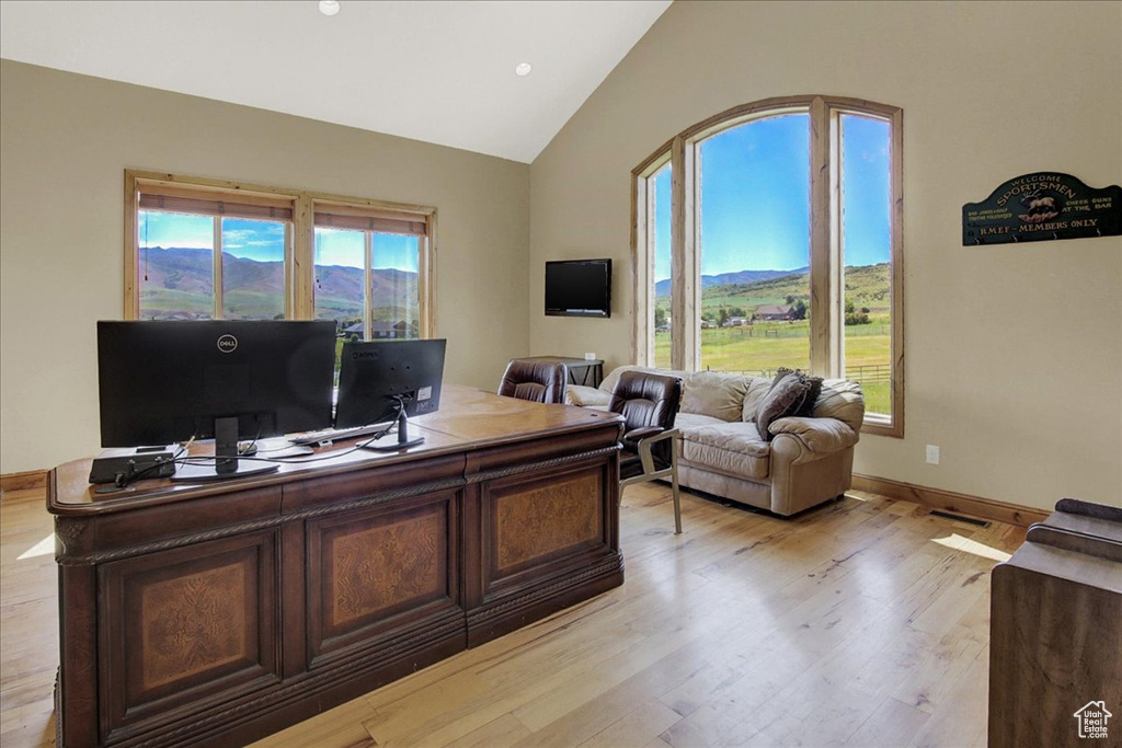 Office featuring visible vents, light wood-style floors, high vaulted ceiling, and baseboards
