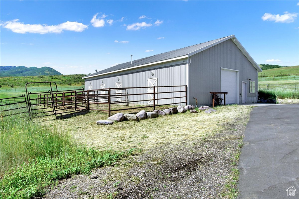 View of outdoor structure with fence, a rural view, an outdoor structure, and a mountain view