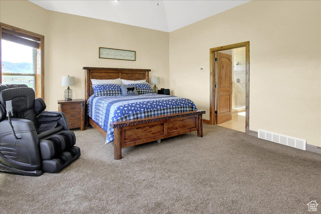 Carpeted bedroom featuring connected bathroom, visible vents, lofted ceiling, and baseboards