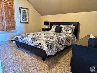 Carpeted bedroom featuring lofted ceiling