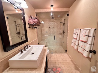 Full bath with baseboards, a shower stall, toilet, and vanity