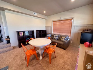 Living room with recessed lighting, carpet floors, and a wainscoted wall