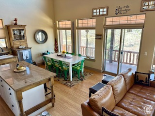 Living area with baseboards, light wood-style flooring, and a high ceiling