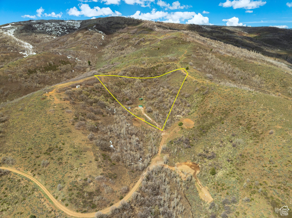 Aerial view of property and surrounding area featuring a mountain backdrop and property parcel outlined