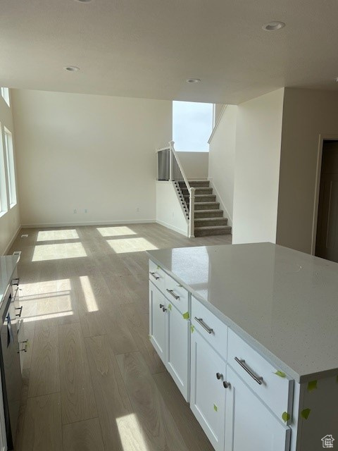 Interior space featuring baseboards, stairway, wood finished floors, and recessed lighting