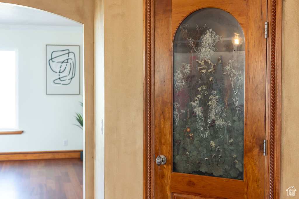 Room details featuring arched walkways, wood finished floors, and baseboards