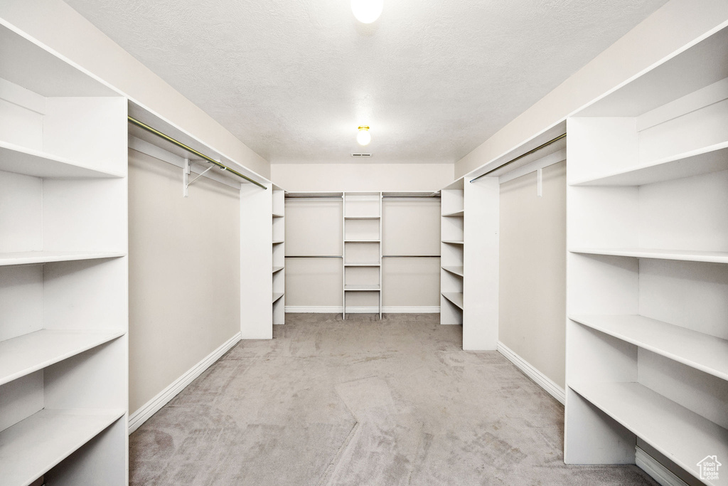 Spacious closet with light colored carpet