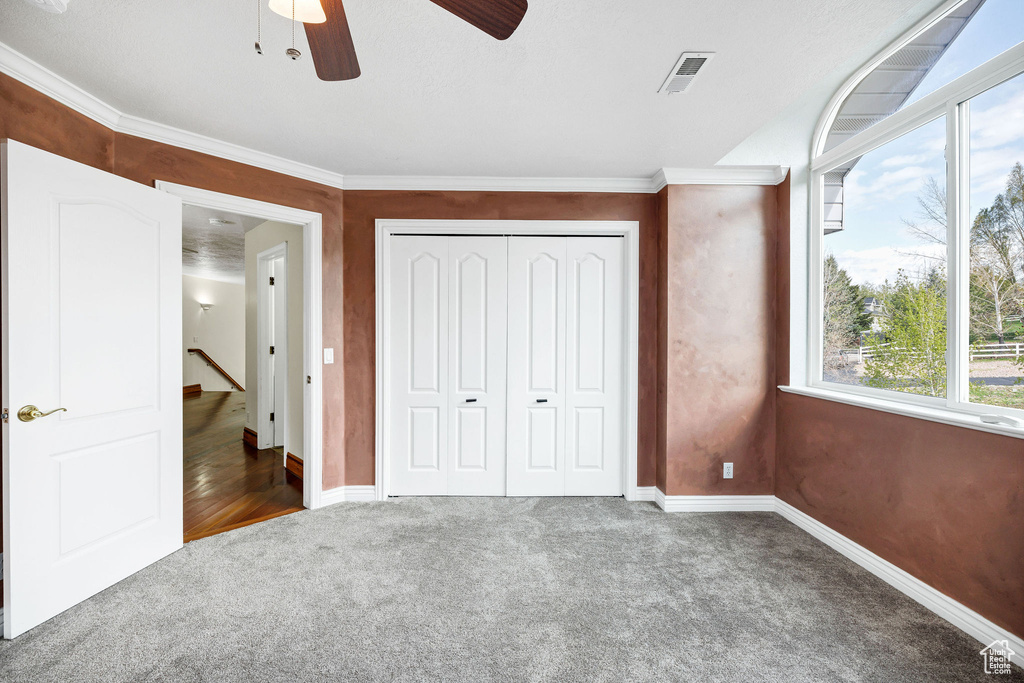 Unfurnished bedroom featuring visible vents, a closet, carpet flooring, and multiple windows