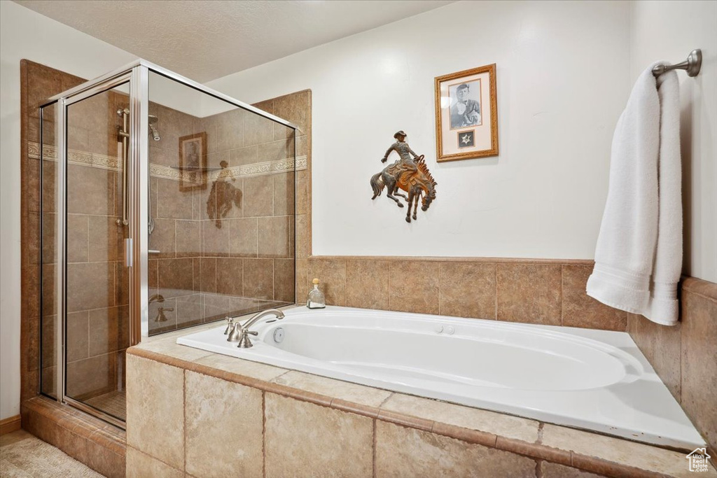 Bathroom featuring a stall shower and a bath