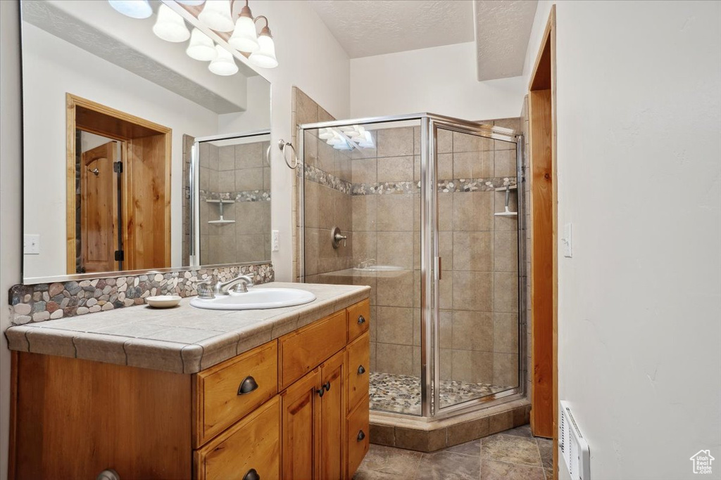 Full bath featuring visible vents, a shower stall, and vanity