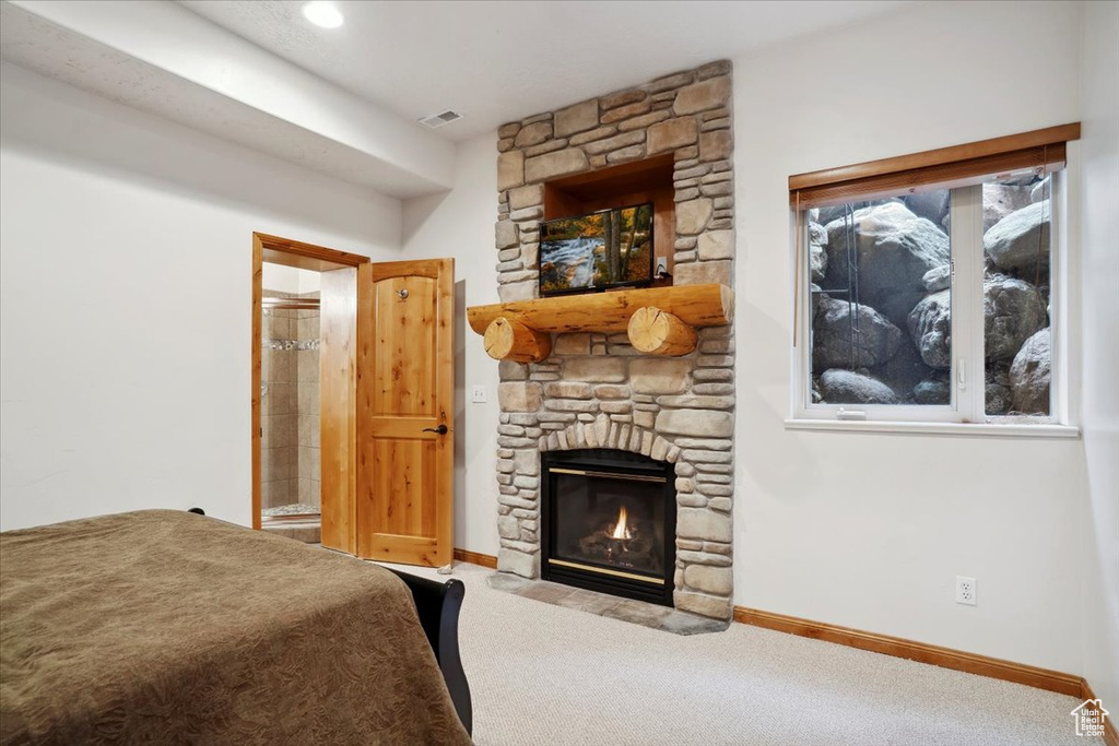 Bedroom featuring baseboards, carpet floors, connected bathroom, and a fireplace