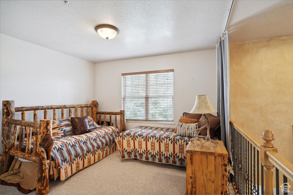 Bedroom featuring a textured ceiling and carpet floors