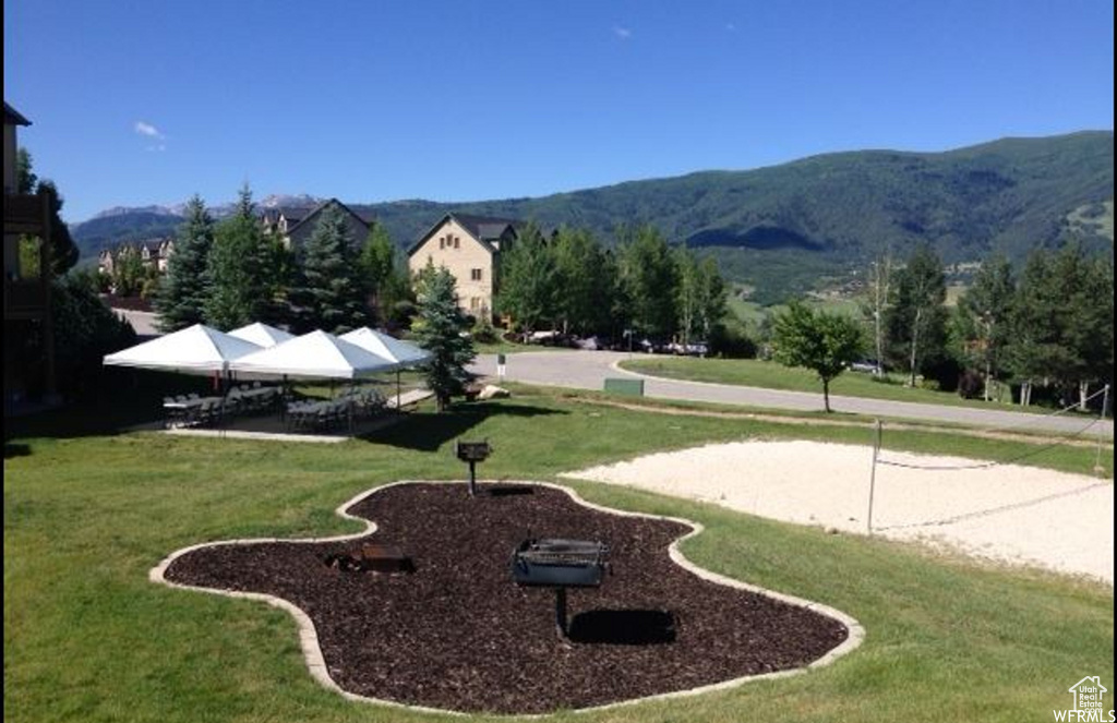 Surrounding community featuring a mountain view, volleyball court, and a lawn