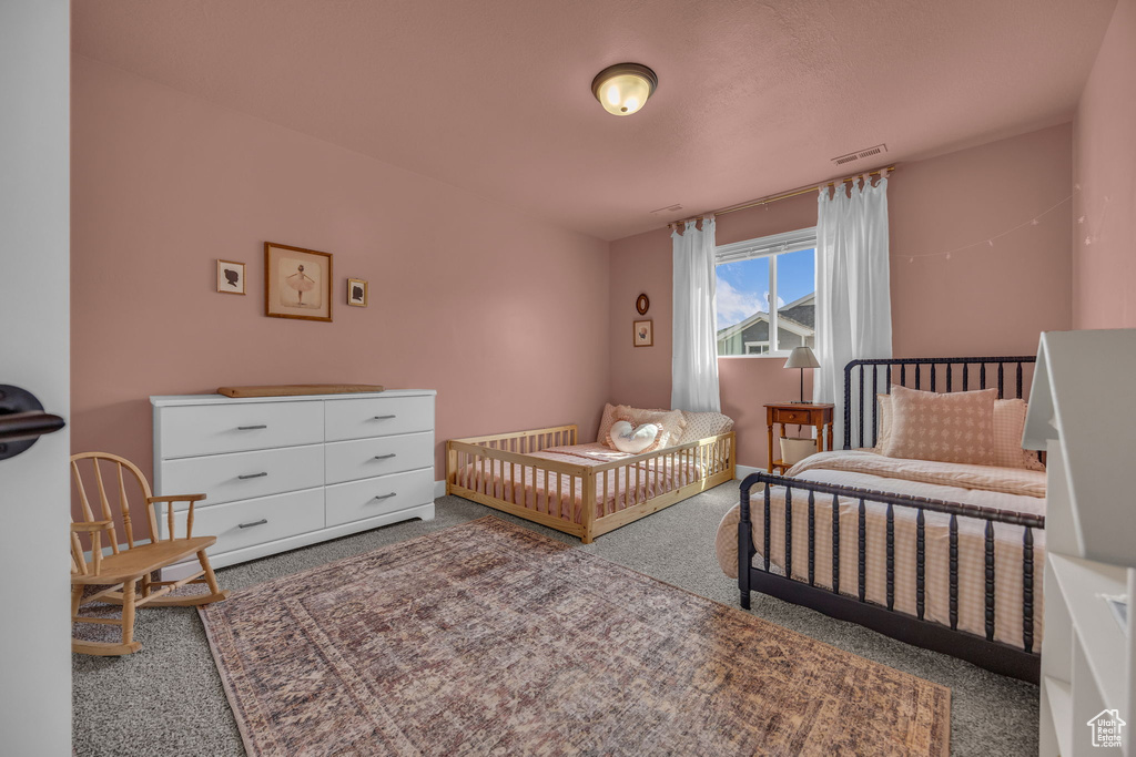 Bedroom with visible vents and carpet flooring