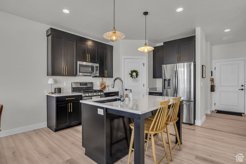 Kitchen featuring light wood-style flooring, appliances with stainless steel finishes, baseboards, and a sink