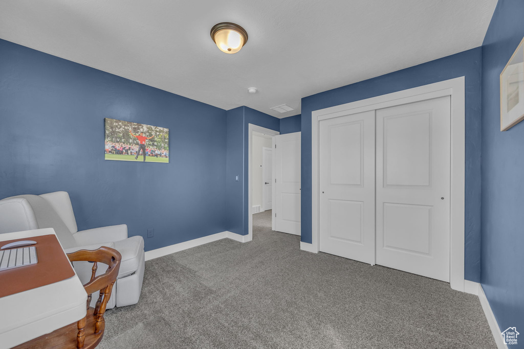 Living area with baseboards and carpet
