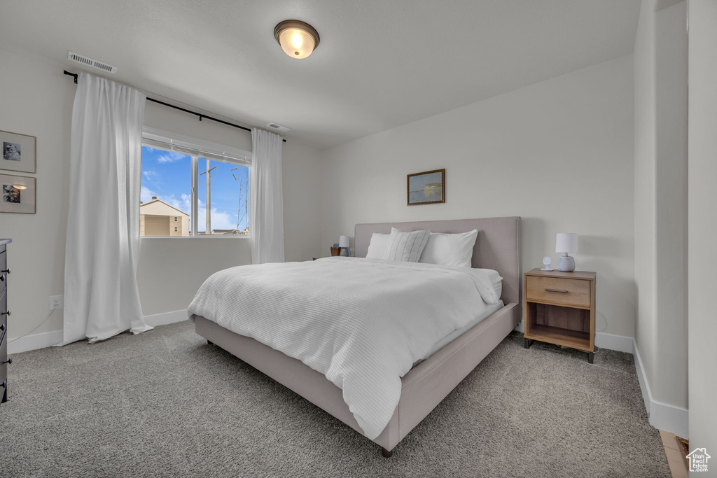 Bedroom featuring baseboards, visible vents, and carpet flooring