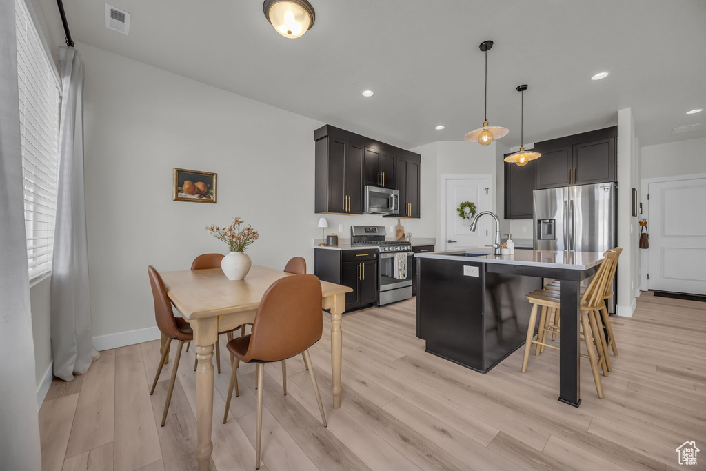 Kitchen with a sink, light countertops, light wood-style flooring, appliances with stainless steel finishes, and visible vents
