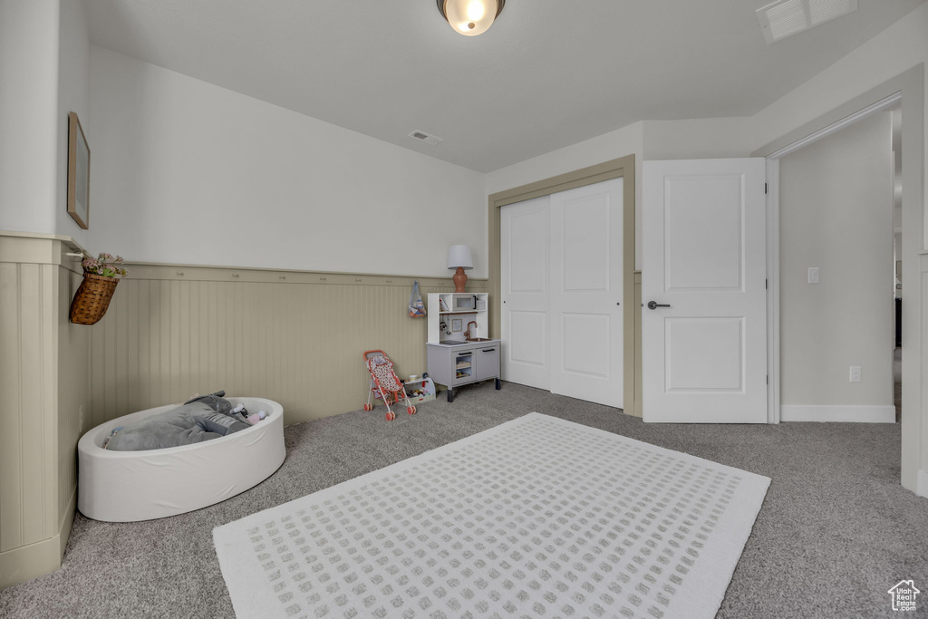 Game room featuring a wainscoted wall, visible vents, and carpet