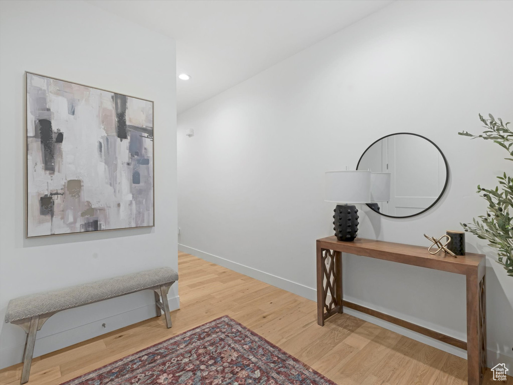 Hallway with wood finished floors, recessed lighting, and baseboards