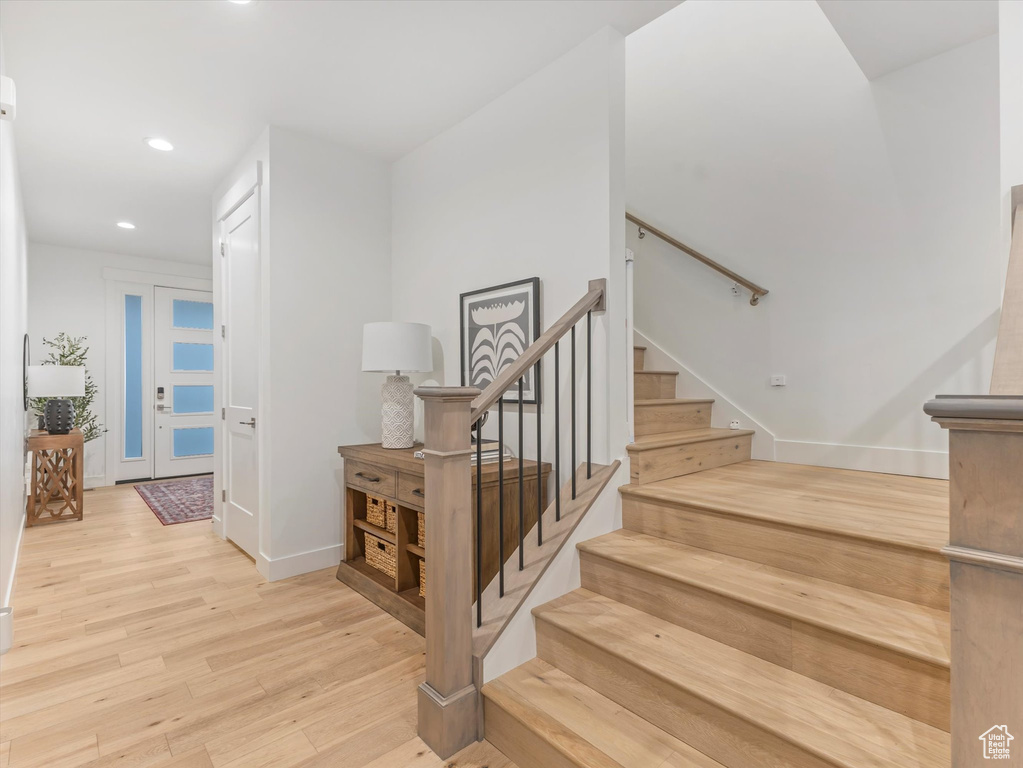 Stairway with recessed lighting, wood finished floors, and baseboards