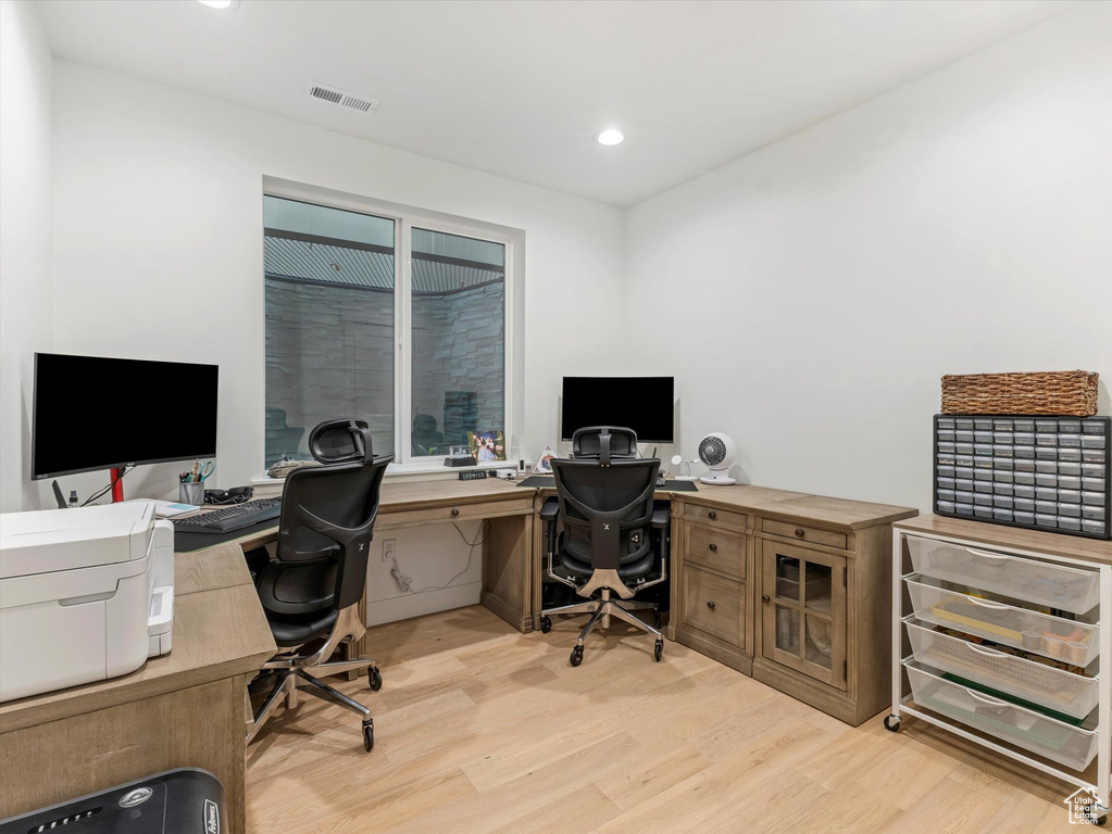 Office area with visible vents, light wood-type flooring, and recessed lighting