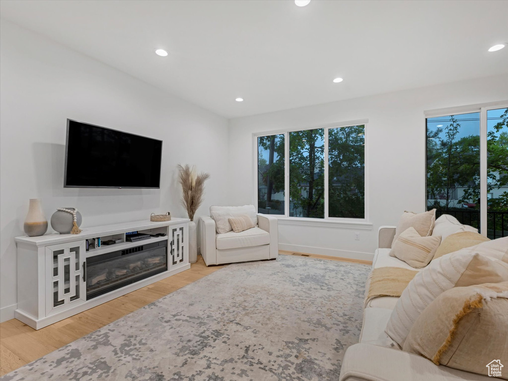 Living area featuring recessed lighting, a wealth of natural light, wood finished floors, and baseboards
