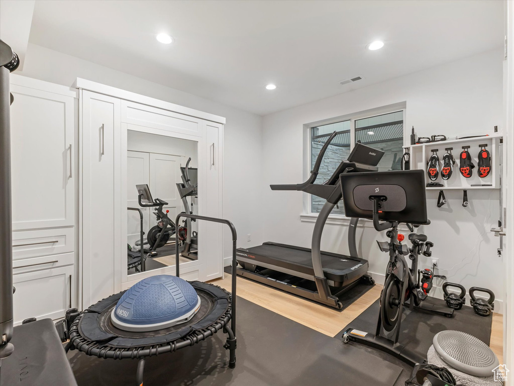 Exercise room with visible vents, light wood-type flooring, recessed lighting, and baseboards