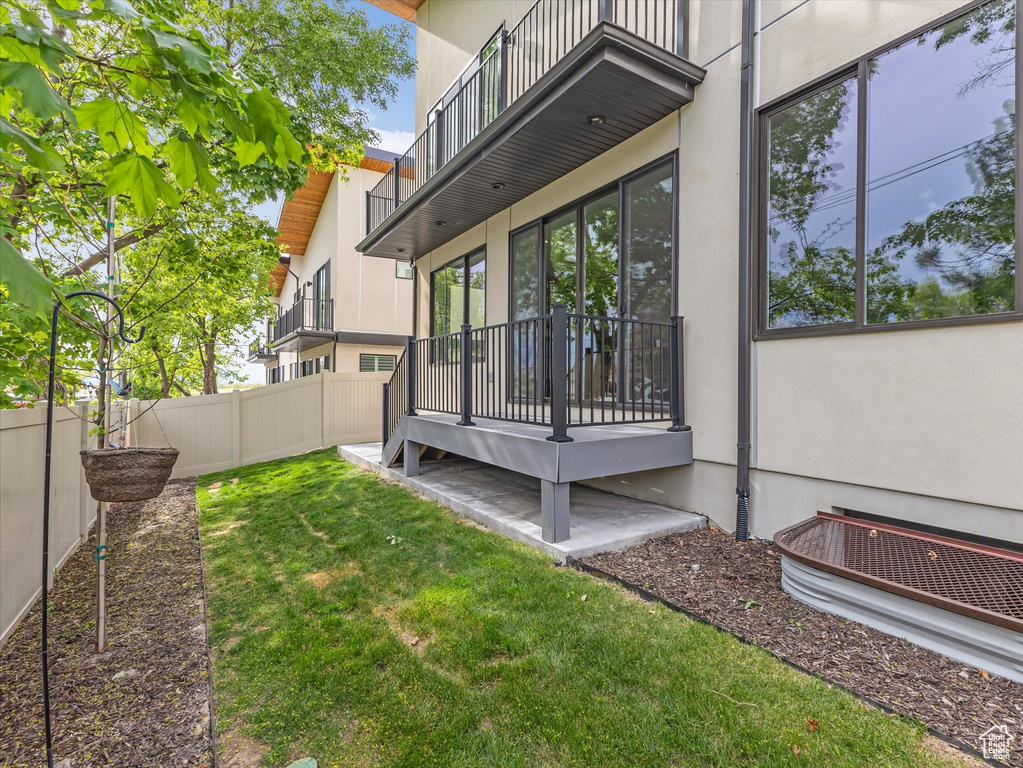 View of yard with fence and a balcony