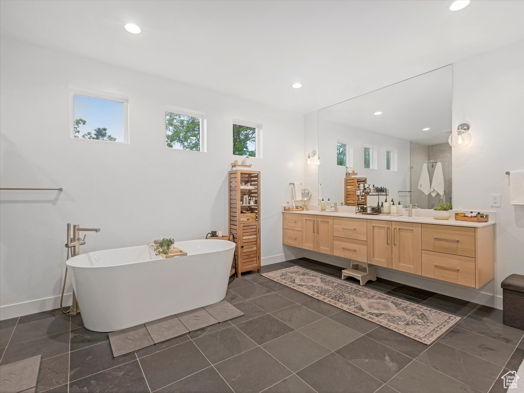 Full bathroom featuring vanity, recessed lighting, a freestanding bath, and baseboards