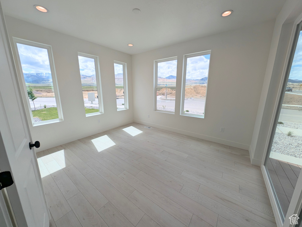 Spare room with recessed lighting, baseboards, and light wood finished floors