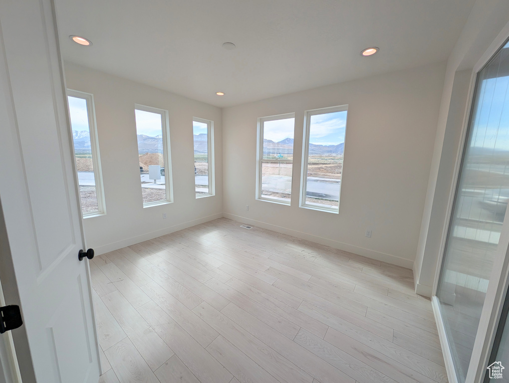 Unfurnished room with light wood-style flooring, baseboards, recessed lighting, and a mountain view