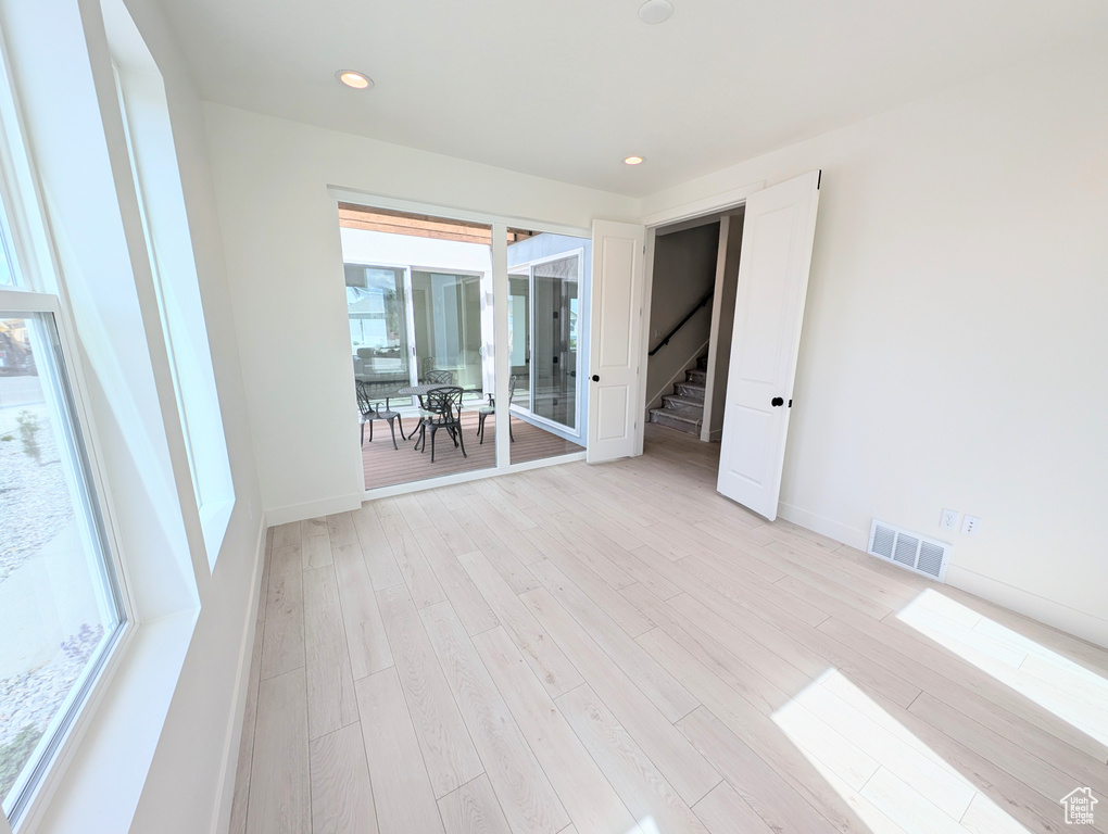 Unfurnished room featuring light wood-type flooring, baseboards, and recessed lighting