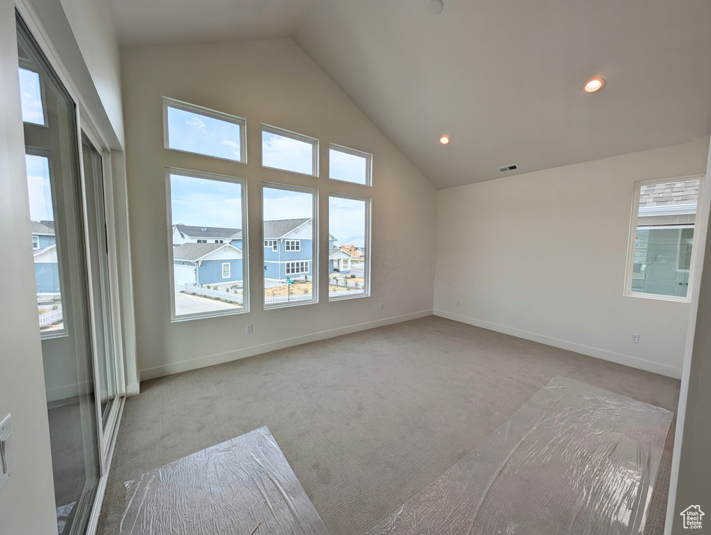 Interior space featuring recessed lighting, carpet, lofted ceiling, and baseboards