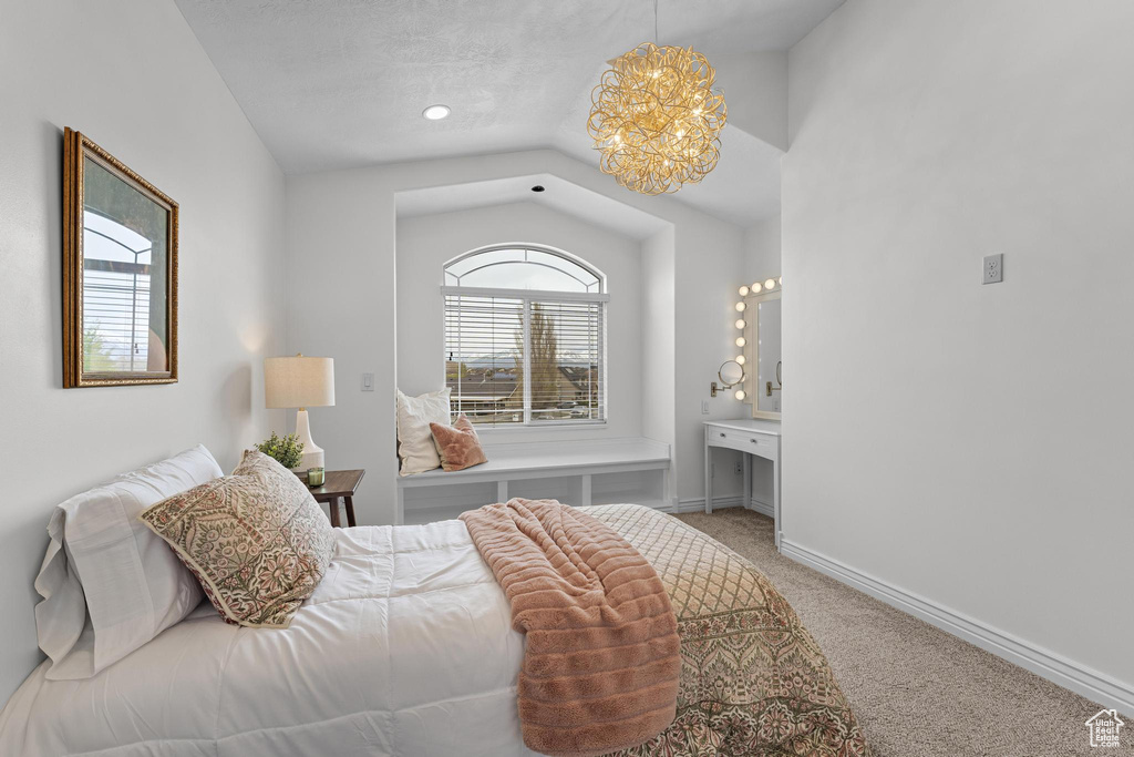 Bedroom with lofted ceiling, a notable chandelier, carpet, and baseboards