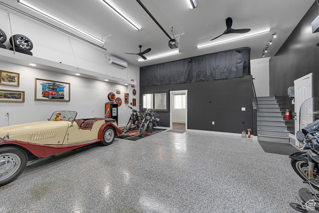 Garage with a wall mounted AC, a garage door opener, and baseboards