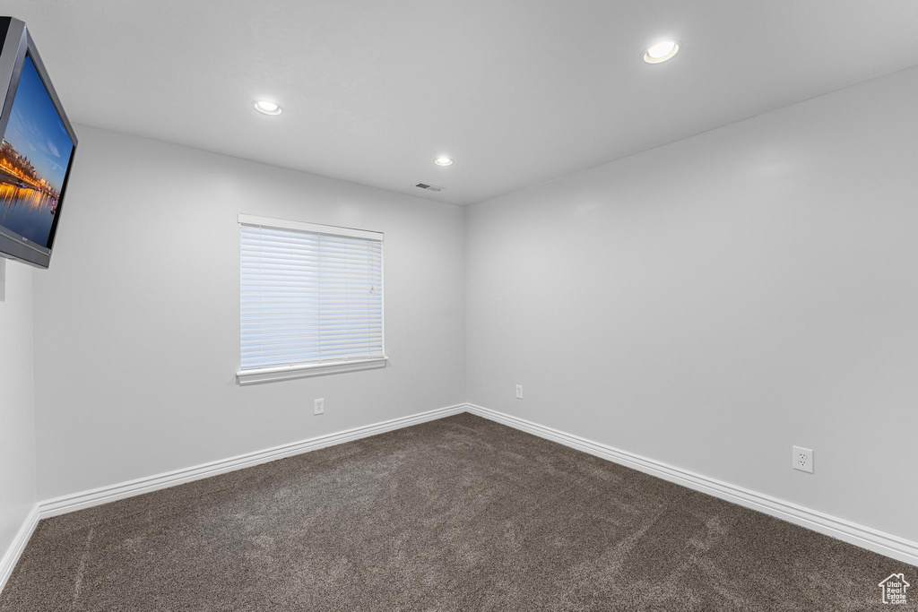 Spare room with visible vents, dark colored carpet, baseboards, and recessed lighting
