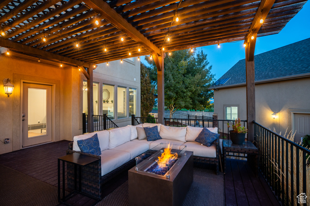 Wooden terrace with an outdoor living space with a fire pit and a pergola