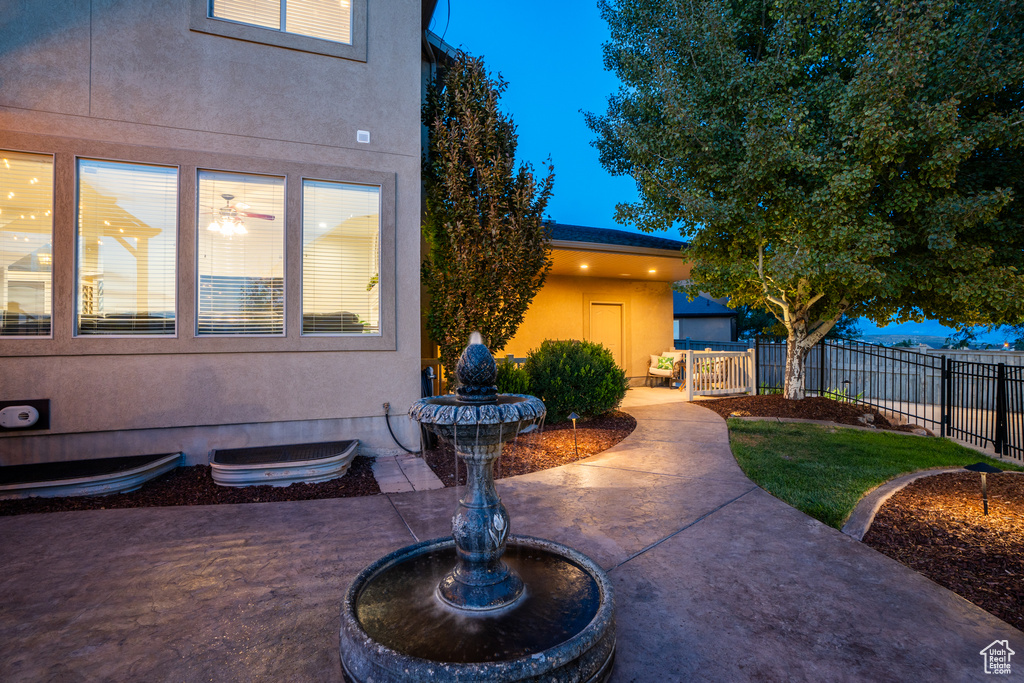 View of front of home featuring fence, stucco siding, and a patio area